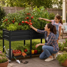 2-Tier Elevated Metal Wicking Garden Bed with Lockable Wheels & Storage Shelf, Dark Gray Staggered Self-Watering Planter. Built-in tank feeds plants via capillary action for veggies, herbs, flowers